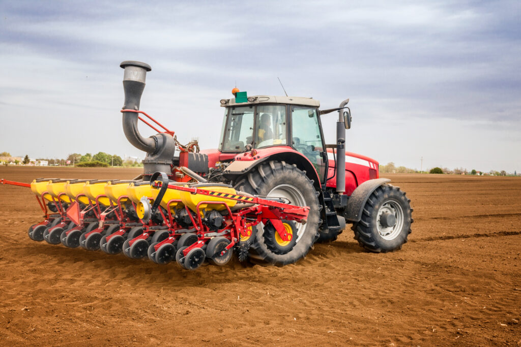 tracteur rouge avec remorque dans un champ de terre